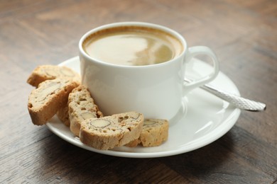 Photo of Traditional Italian almond biscuits (Cantucci) and coffee on wooden table, closeup