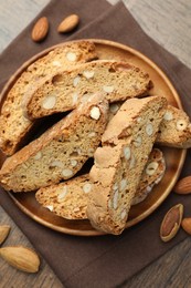 Photo of Traditional Italian almond biscuits (Cantucci) and nuts on wooden table, top view