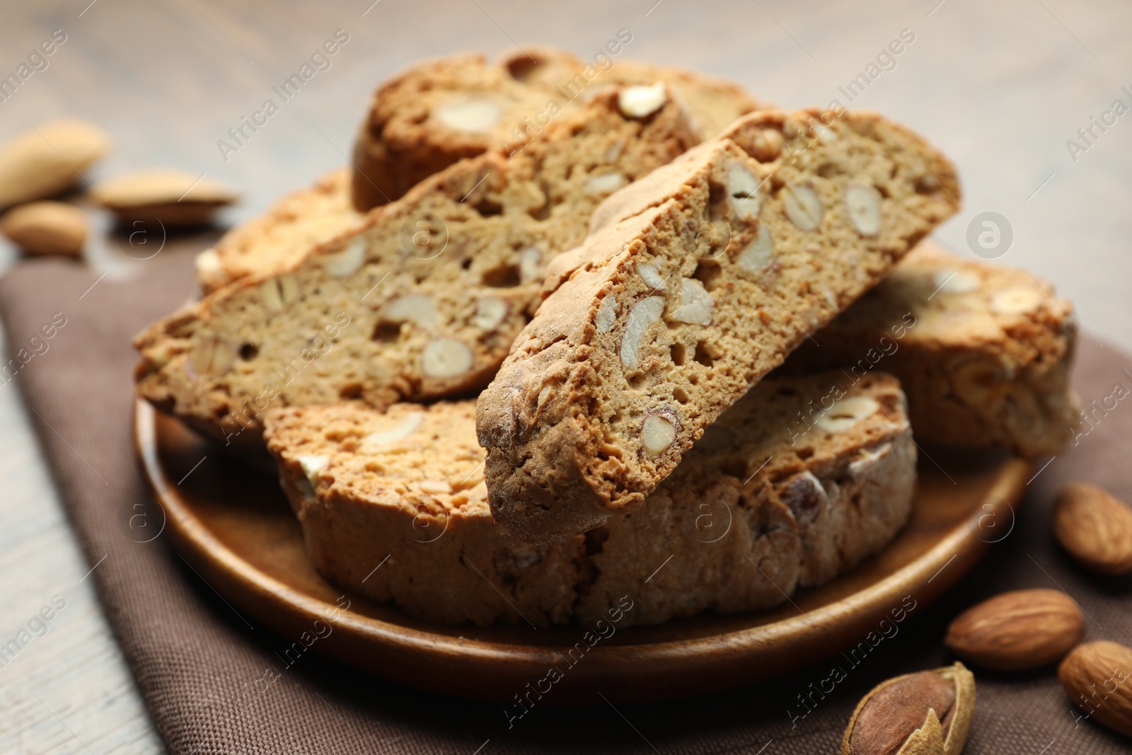 Photo of Traditional Italian almond biscuits (Cantucci) and nuts on table, closeup