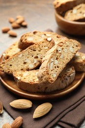 Photo of Traditional Italian almond biscuits (Cantucci) and nuts on table, closeup