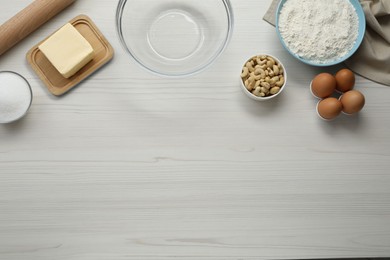 Photo of Different ingredients for cookies on white wooden table, flat lay. Space for text