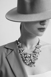 Black-and-white portrait of stylish young woman with luxury necklace