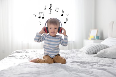 Image of Cute little baby in headphones on bed at home. Music notes flying around child