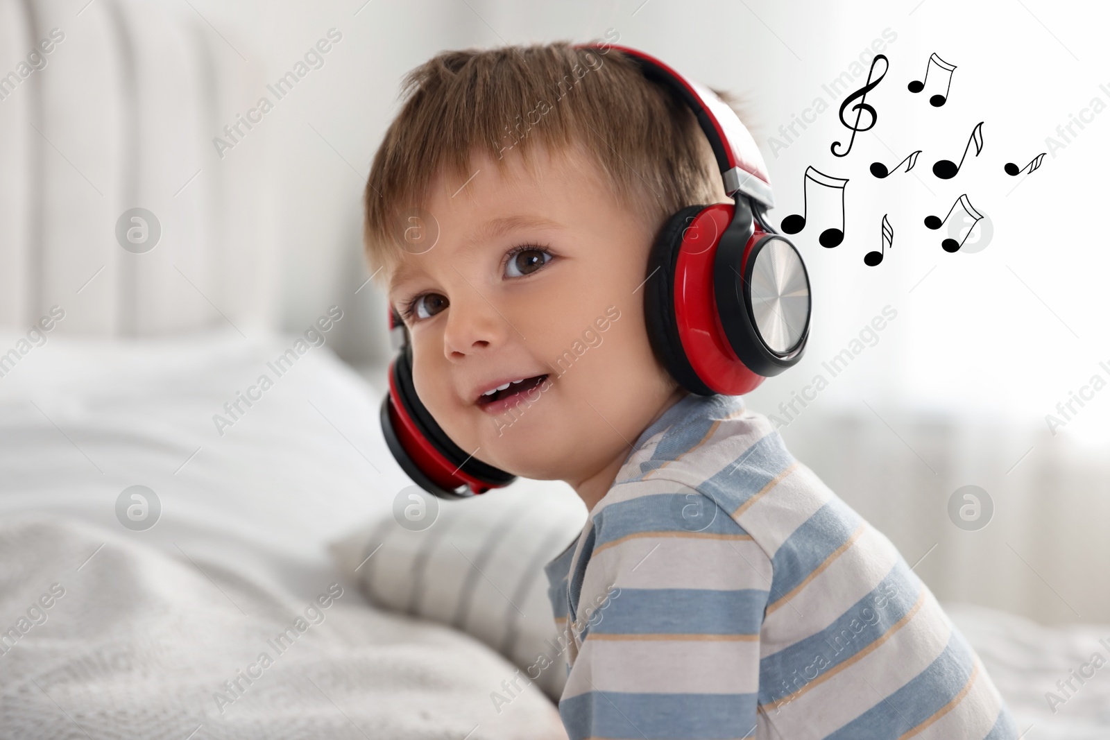 Image of Cute little baby in headphones at home. Music notes flying near child