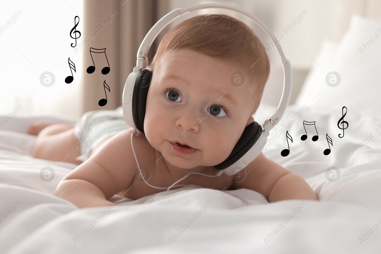 Image of Cute little baby with headphones on bed at home. Music notes flying near child