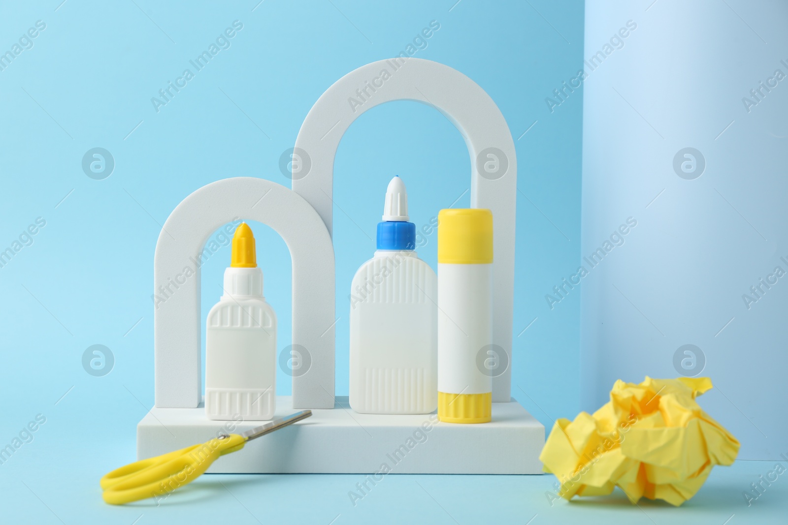 Photo of Composition with scissors and glue on light blue background