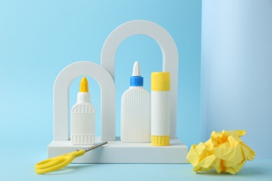 Photo of Composition with scissors and glue on light blue background