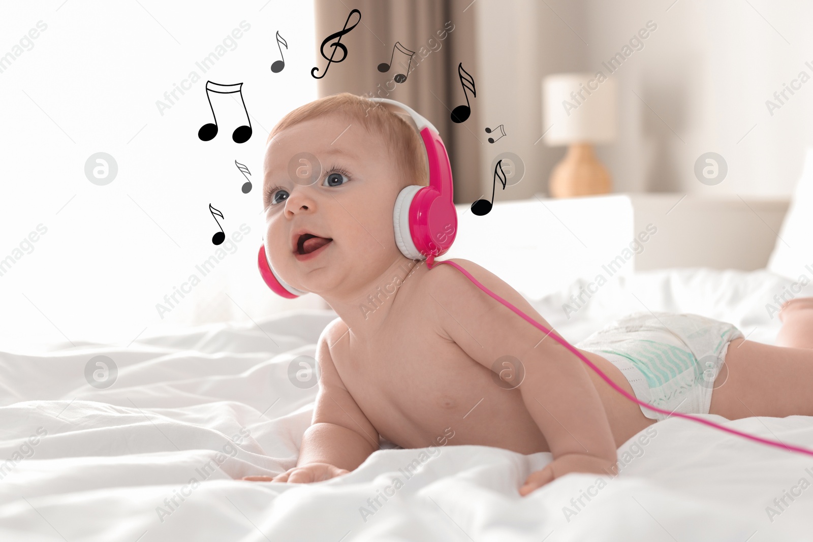 Image of Cute little baby with headphones on bed at home. Music notes flying near child