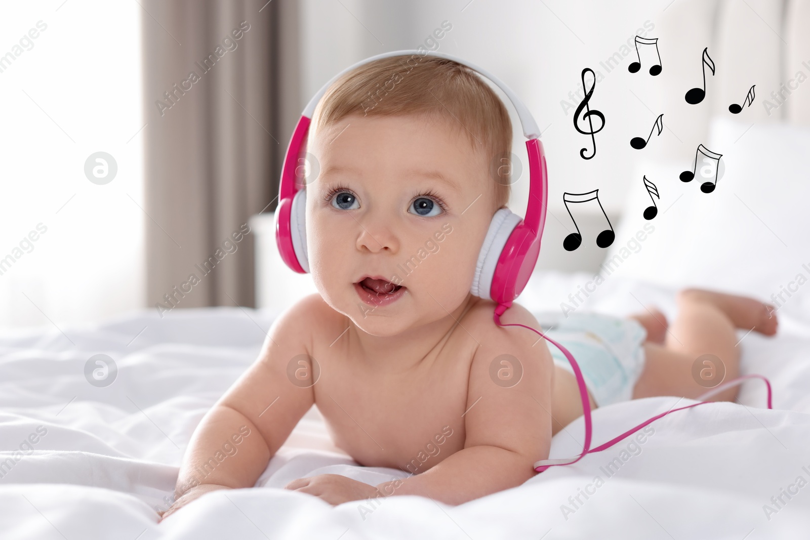 Image of Cute little baby with headphones on bed at home. Music notes flying near child