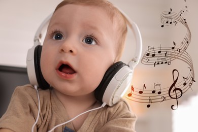 Image of Cute little baby with headphones at home. Music notes flying near child