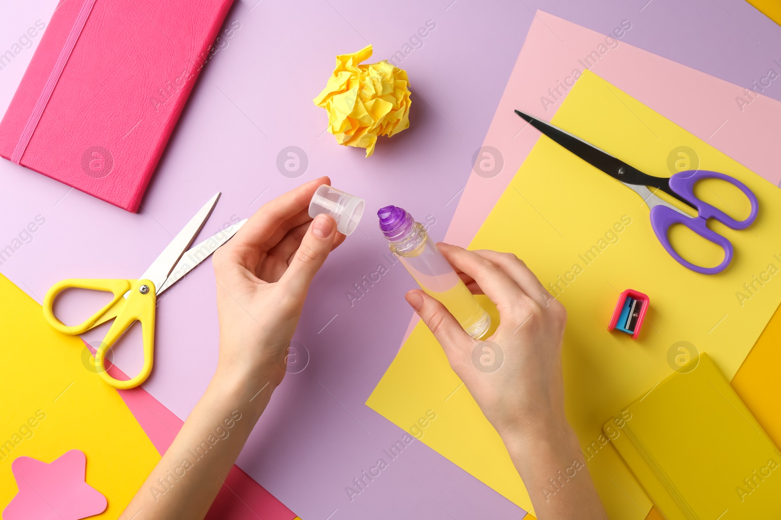 Photo of Woman with glue, scissors and colorful paper at table, top view