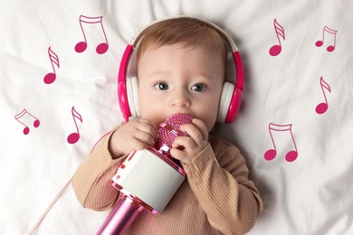 Image of Cute little baby with headphones and microphone lying on bed, top view. Music notes flying near child