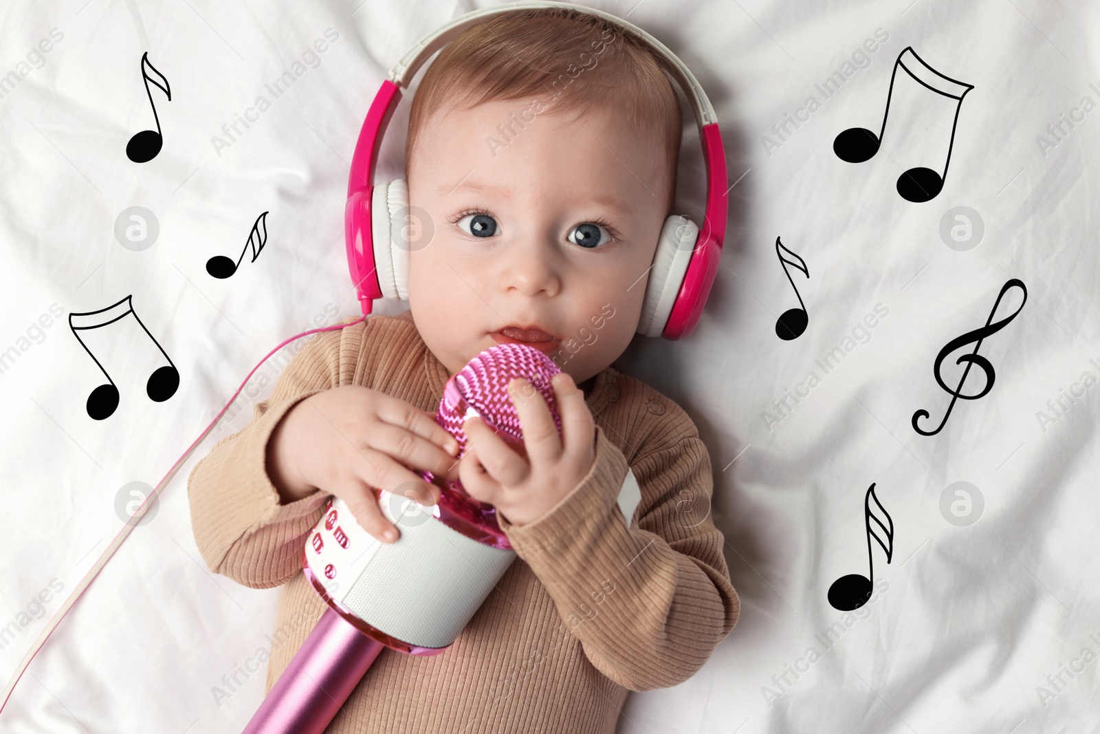 Image of Cute little baby with headphones and microphone lying on bed, top view. Music notes flying near child