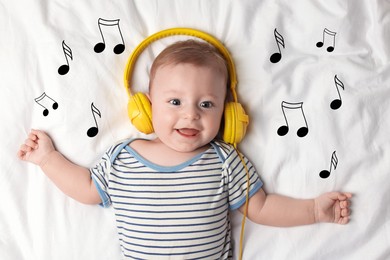 Cute little baby with headphones lying on bed, top view. Music notes flying near child