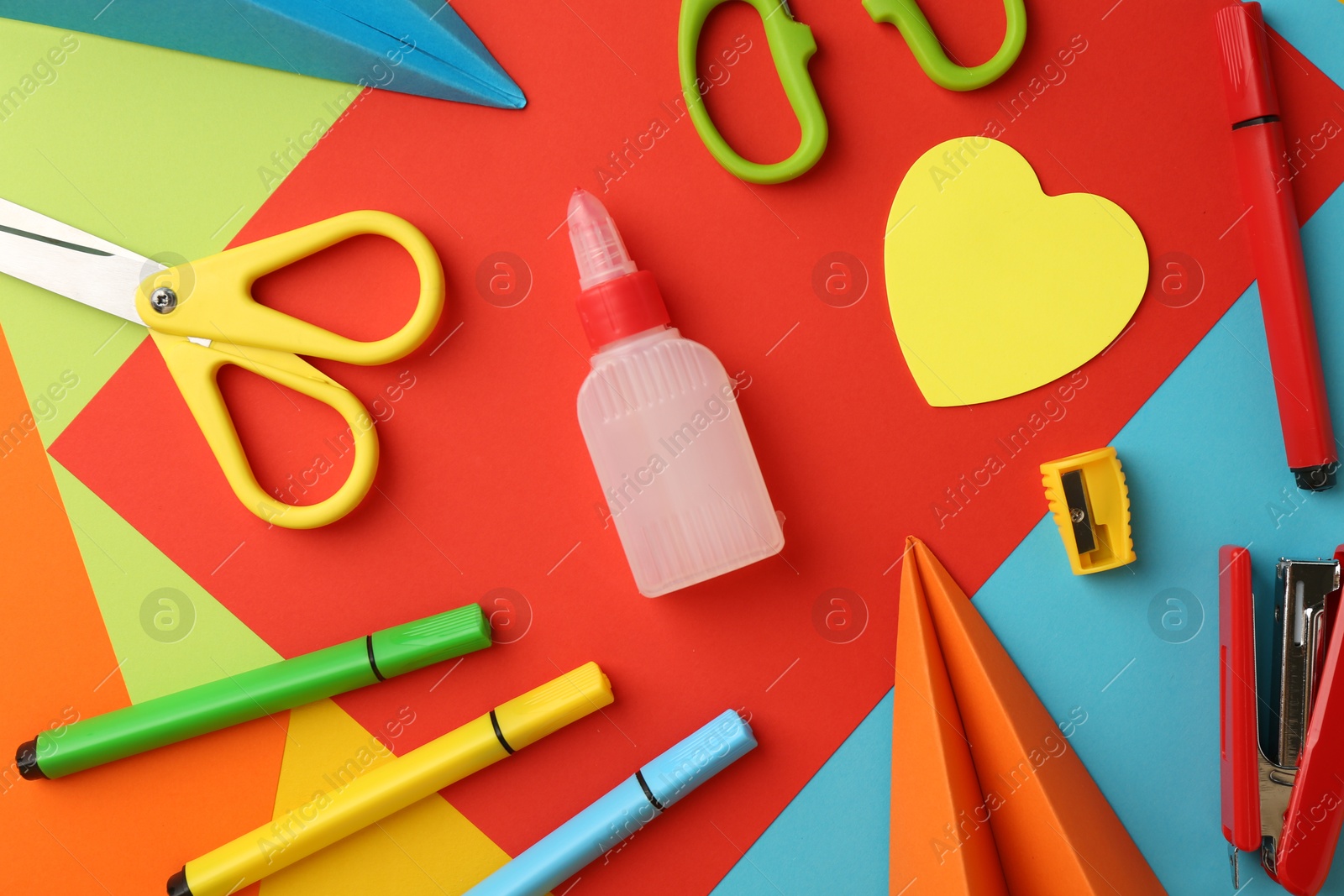 Photo of Flat lay composition with glue, scissors and other stationery on color background