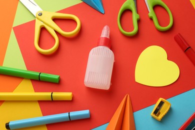 Photo of Flat lay composition with glue, scissors and other stationery on color background