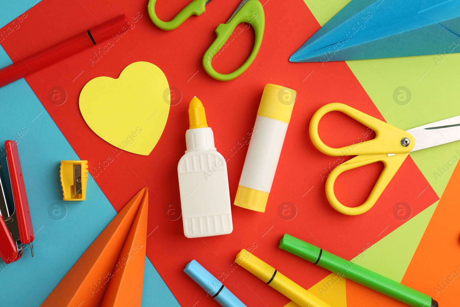 Photo of Flat lay composition with glue, scissors and other stationery on color background