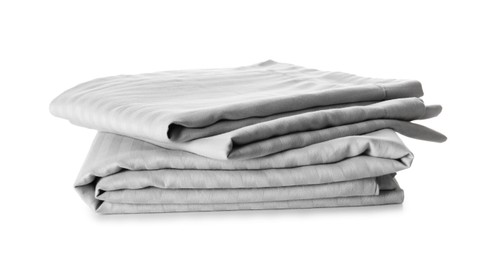 Stack of clean bed sheets isolated on white