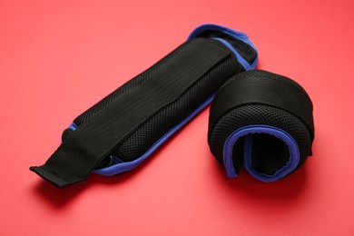 Photo of Stylish blue ankle weights on red background