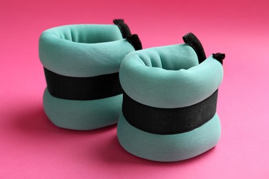 Stylish turquoise ankle weights on pink background