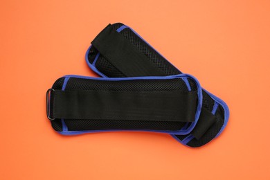 Photo of Blue ankle weights on orange background, flat lay