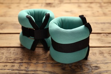 Photo of Stylish turquoise ankle weights on wooden table