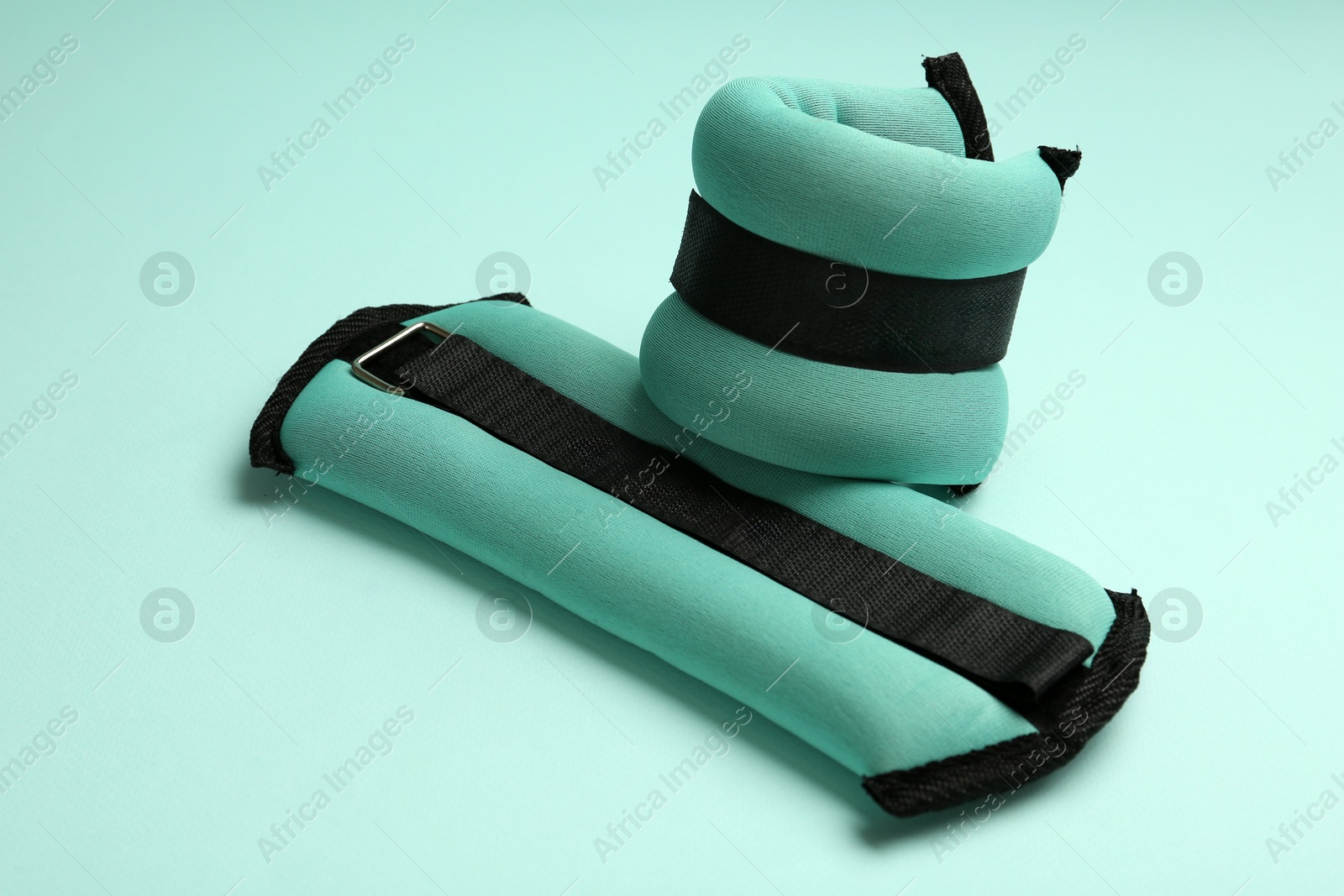 Photo of Stylish turquoise ankle weights on color background