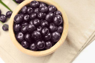 Photo of Ripe acai berries in bowl on white table, top view