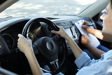 Driving school. Student passing driving test with examiner in car, closeup