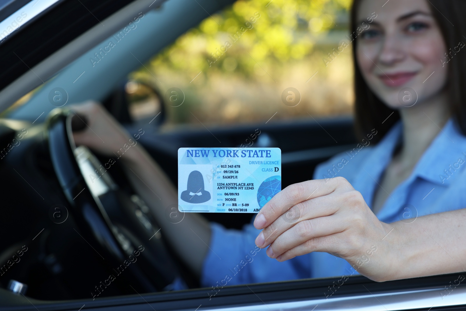 Photo of Driving school. Woman with driving license in car, selective focus