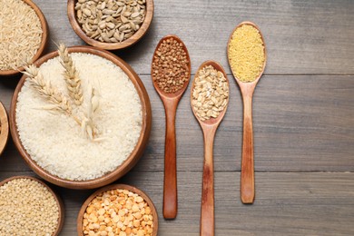 Photo of Different types of cereals and seeds on wooden table, flat lay