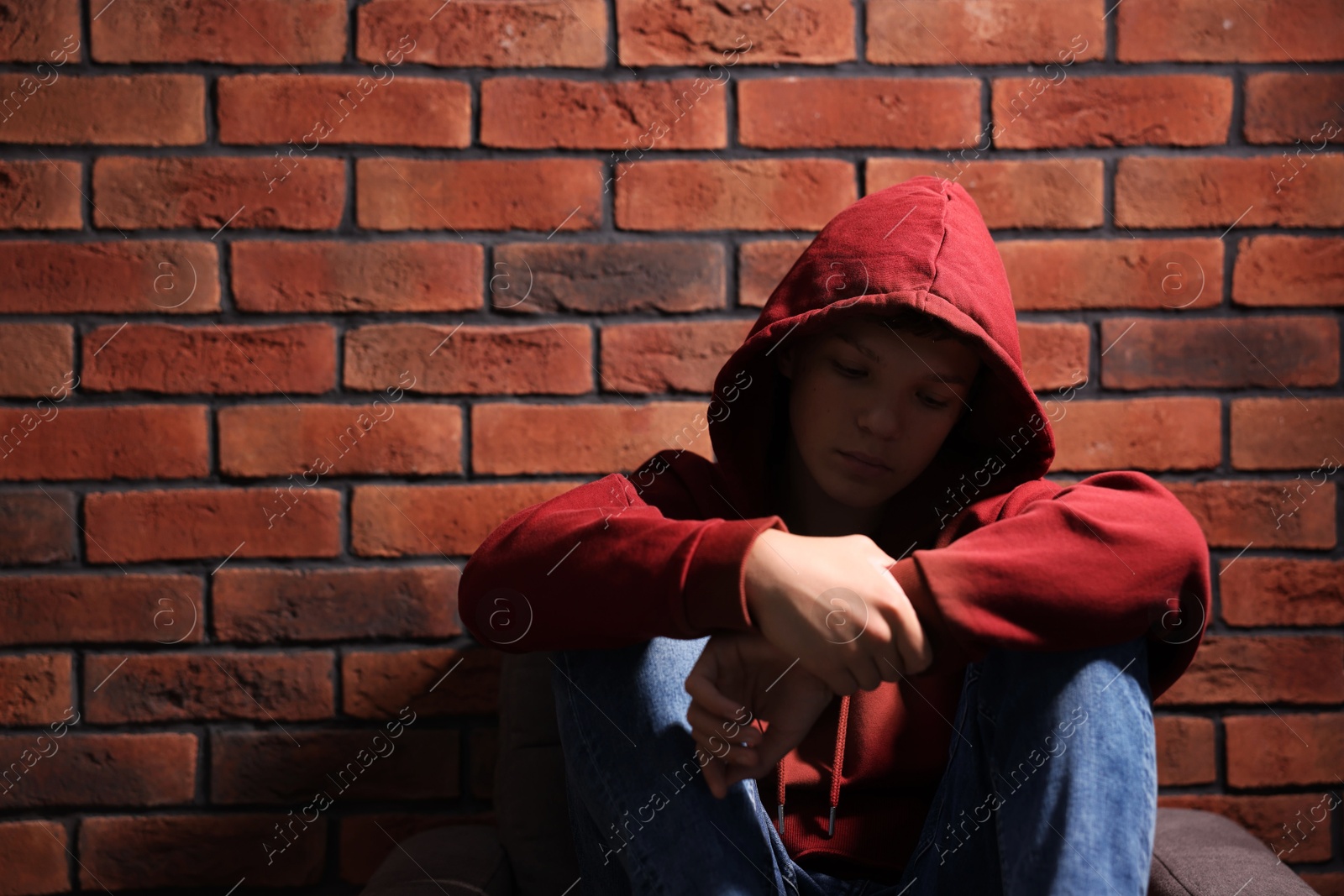 Photo of Loneliness concept. Sad teenage boy near brick wall, space for text