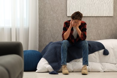 Photo of Loneliness concept. Sad teenage boy on bed at home