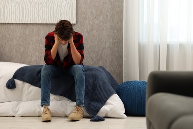 Photo of Loneliness concept. Sad teenage boy on bed at home