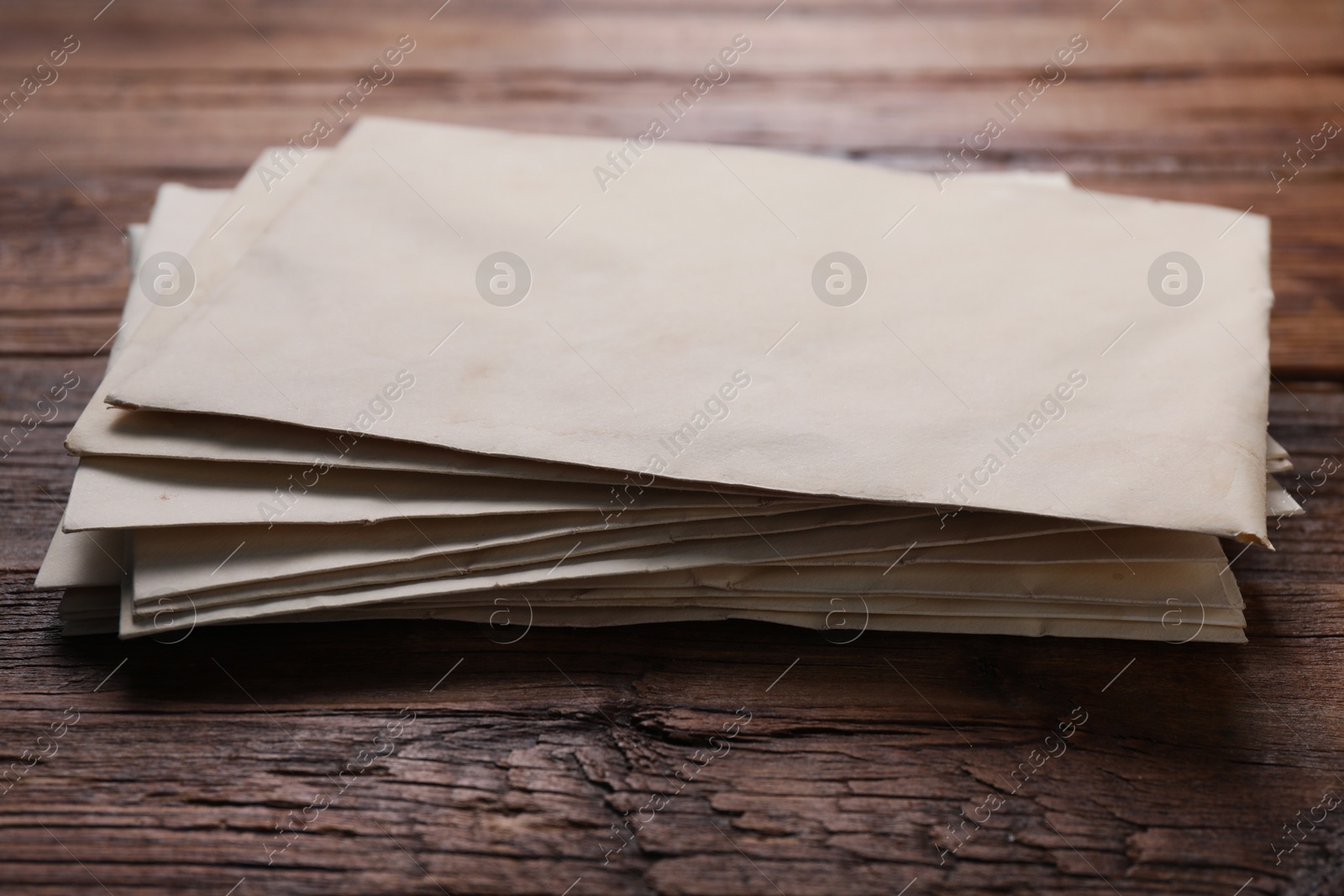 Photo of Old letter envelopes on wooden table, closeup