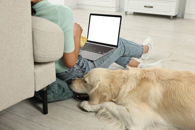 Online pet shop. Woman with laptop, credit card and cute Golden Retriever dog making order on floor at home, closeup