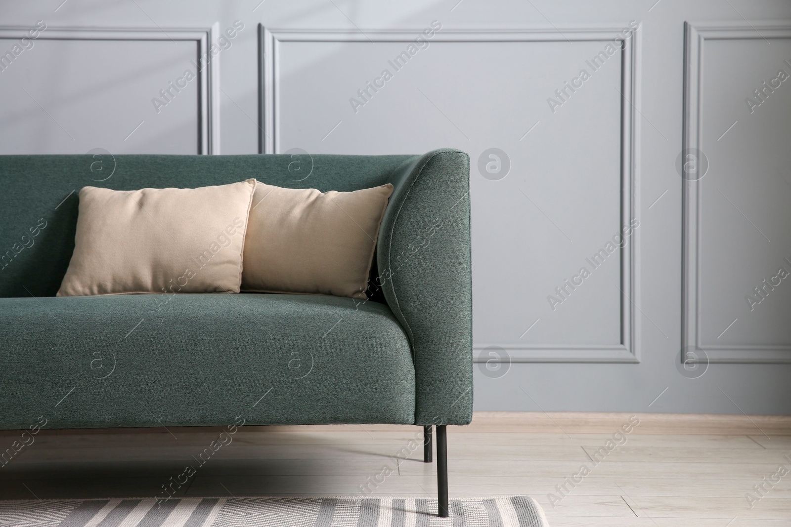 Photo of Comfortable sofa near grey wall in room, space for text