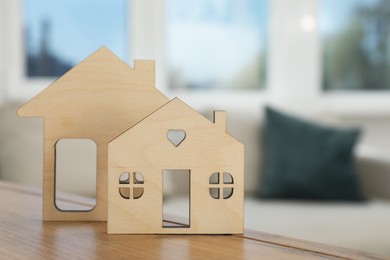 Photo of Models of houses on wooden table indoors, closeup