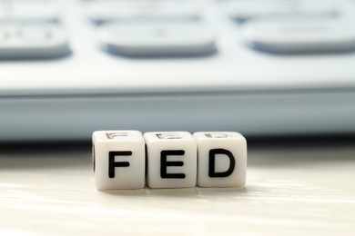 Photo of Cubes with letters Fed (Federal Reserve System) on white table, closeup