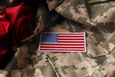 Veterans day. USA army patch and rose flowers on military uniform, closeup