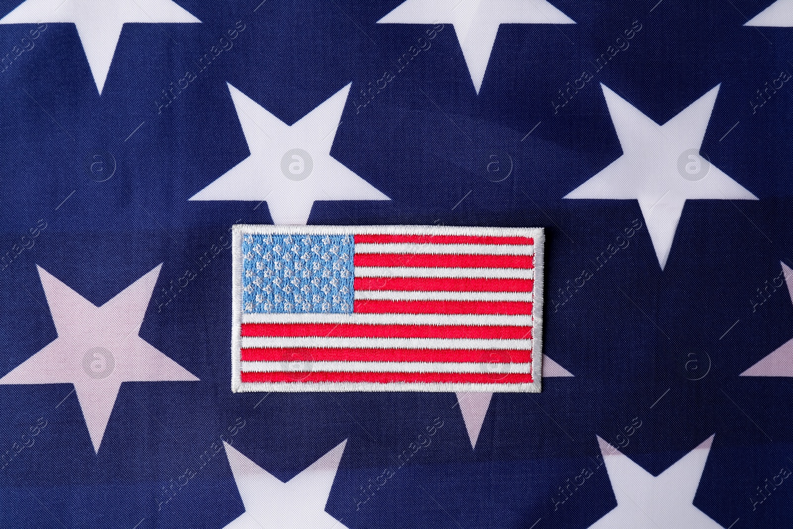 Photo of Veterans day. American army patch on USA flag, top view