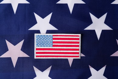 Photo of Veterans day. American army patch on USA flag, top view