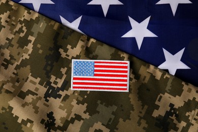 Photo of Veterans day. USA army patch and military uniform on American flag, flat lay