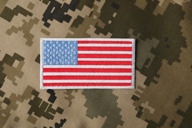 Photo of Veterans day. USA army patch on camouflage fabric, top view