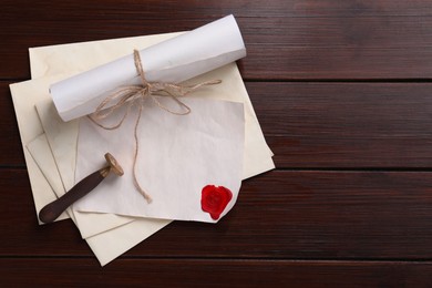 Photo of Old letters, wax stamps and envelopes on wooden table, top view. Space for text