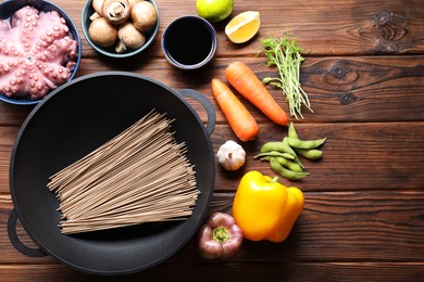 Photo of Different ingredients for wok on wooden table, flat lay