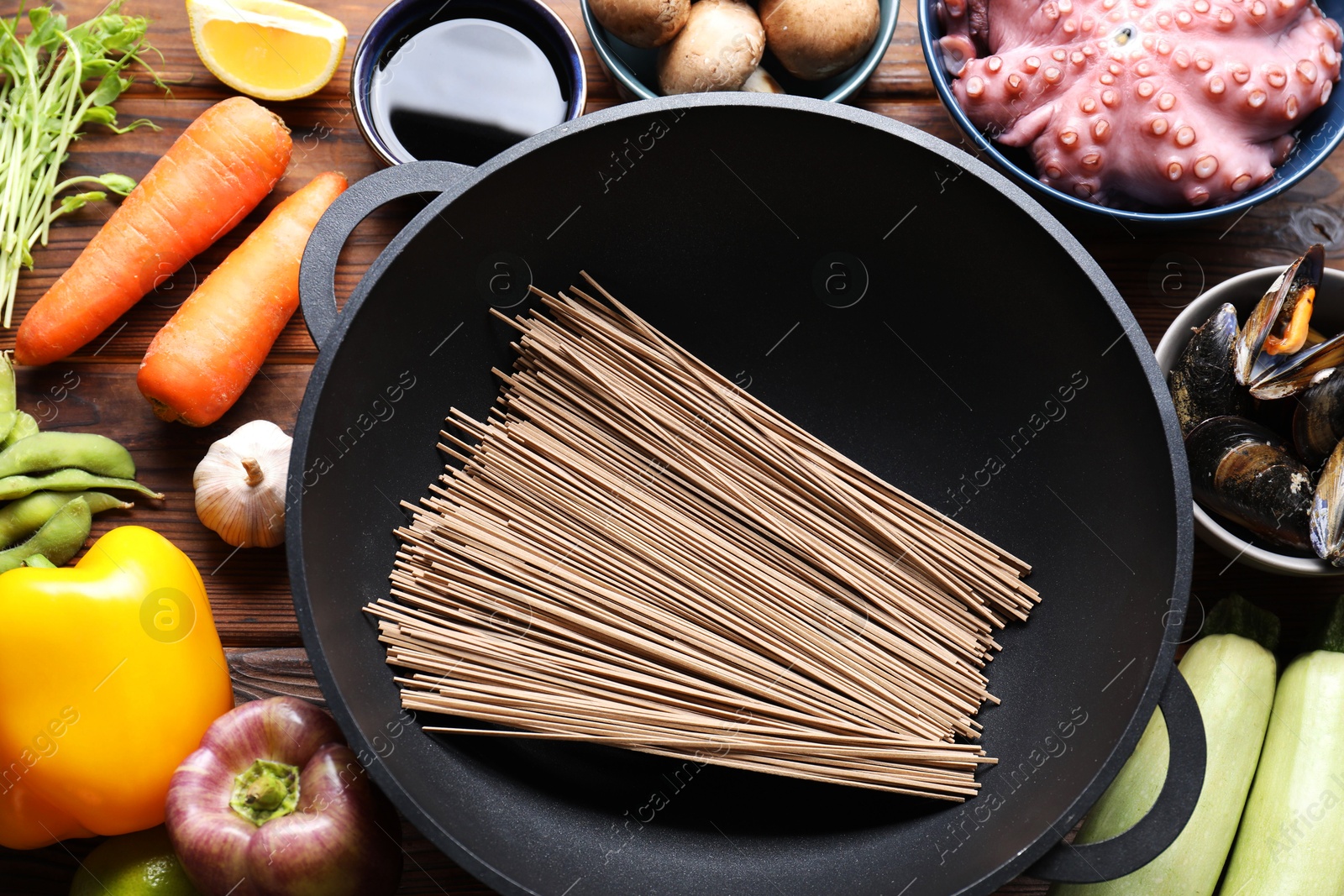 Photo of Different ingredients for wok on wooden table, flat lay