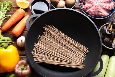 Photo of Different ingredients for wok on wooden table, flat lay