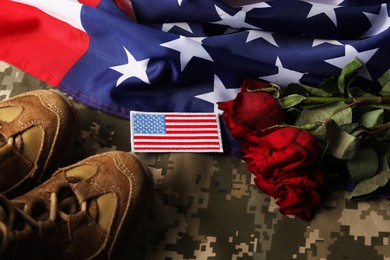 Photo of Veterans day. USA army patch, American flag, roses and military uniform, above view