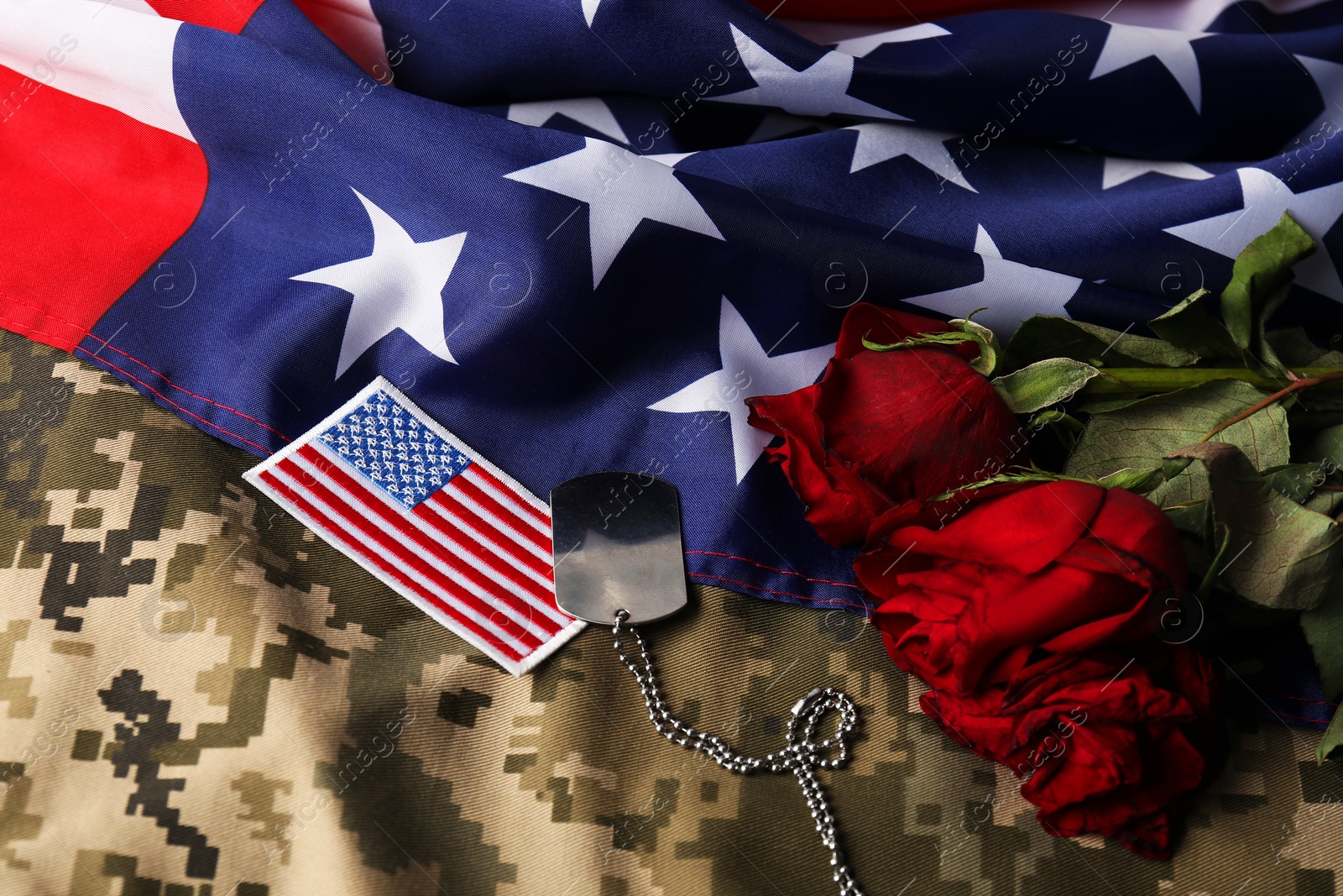 Photo of Veterans day. USA army patch, token, American flag, roses and military uniform, closeup